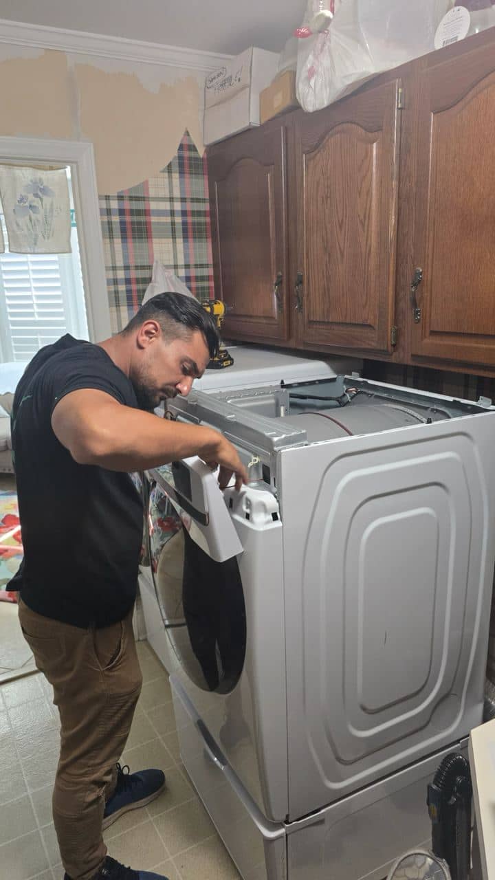 OK Appliance Repair technician working on an opened clothes dryer