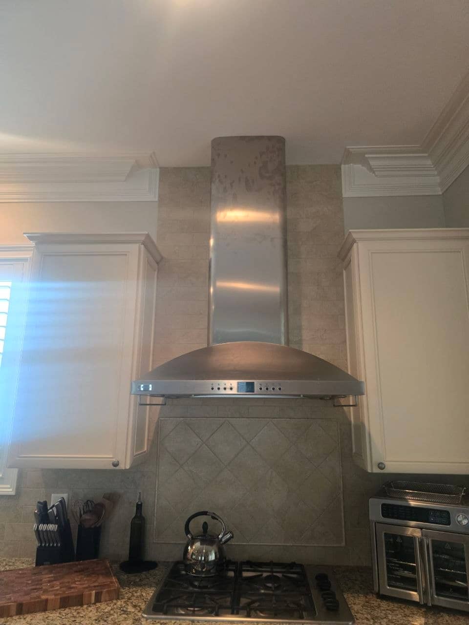 Kitchen range hood before repair with its cooktop lights off